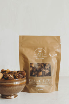 Bag of desert date total body cleanse with a bowl of dates on a white background